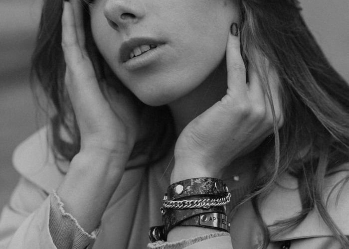 Woman sitting in meditation with a peaceful expression in a sunlit room.